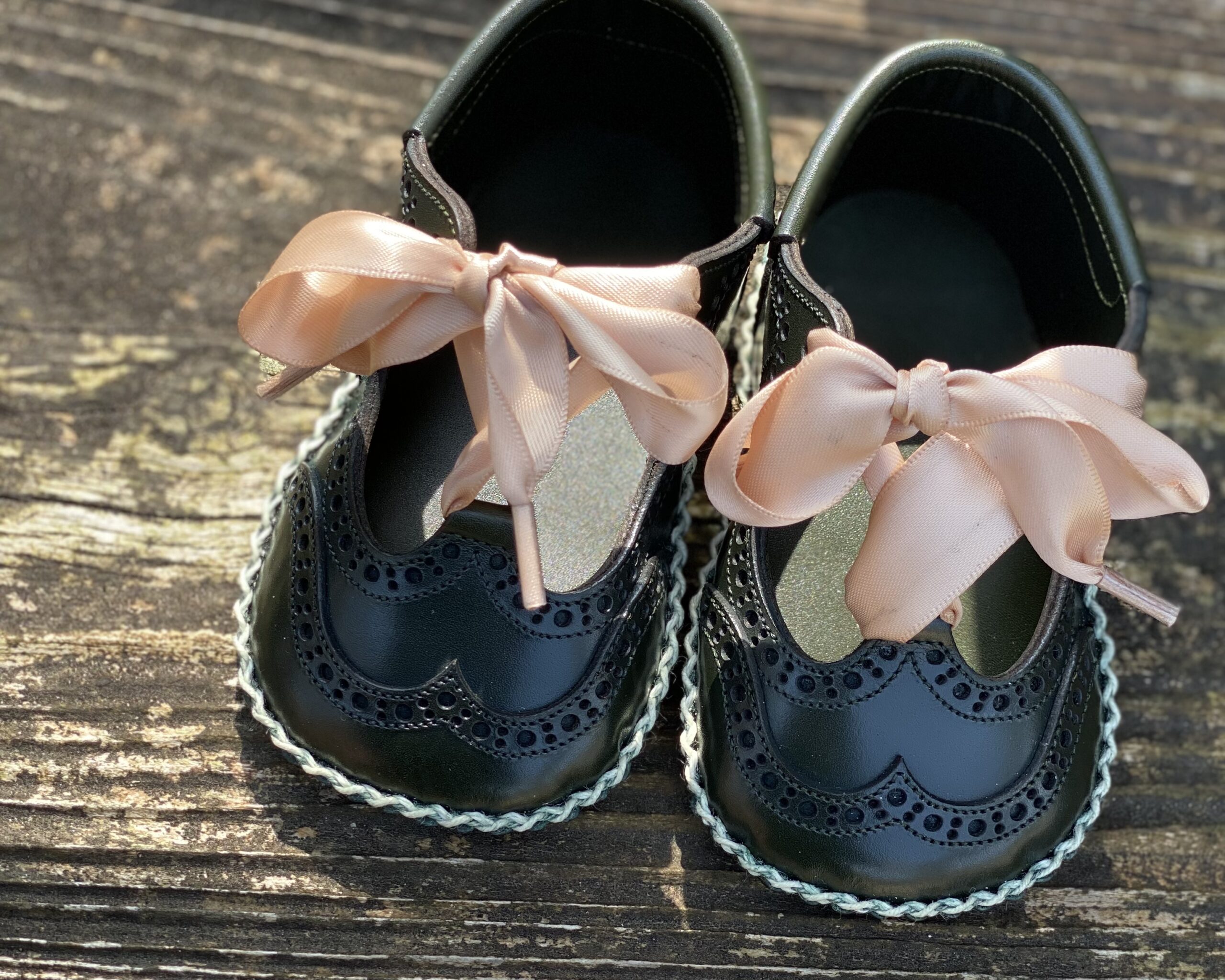 Close-up of hand stitching and edge finishing on leather baby shoes